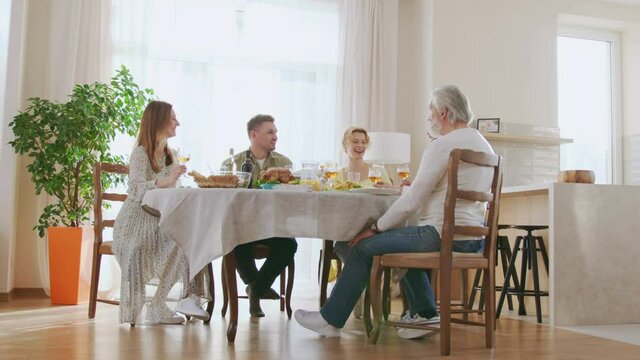 Multiracial senior man having dinner together with his family at home indoor. Relationships and holidays concept