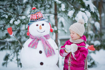 Cute girl is making a snowman.