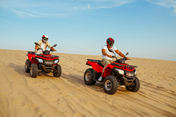 Two racers coming down from the dunes on atv