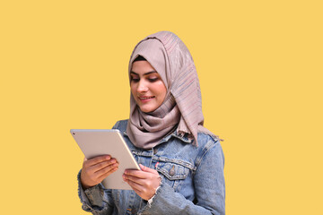 beautiful girl wearing hijab with denim jeans using tab indian pakistani model
