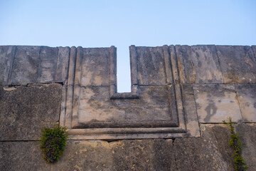 an ancient wall with a window half destroyed
