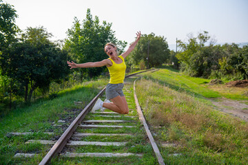 funny girl jumping on the railroad tracks