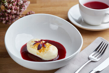 cottage cheese pancakes with berry sauce on wooden table close up. morning table. breakfast concept.