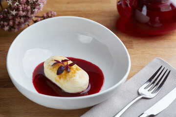 cottage cheese pancakes with berry sauce and red tea. breakfast morning table with flowers.