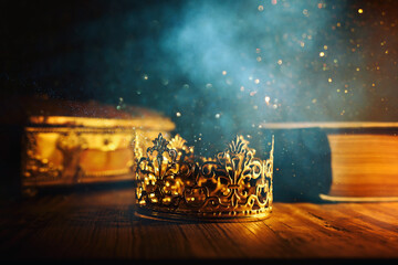 low key image of beautiful queen or king crown and old book. vintage filterd. fantasy medieval period