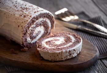 Delicious chocolate roll cake with white cream, homemade baked dessert