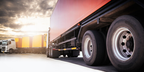 Semi Trailer Trucks Parking lot at The Sunset Sky. Shipping Cargo Container. Truck Wheels Tires....