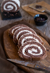 Delicious chocolate roll cake with white cream, homemade baked dessert