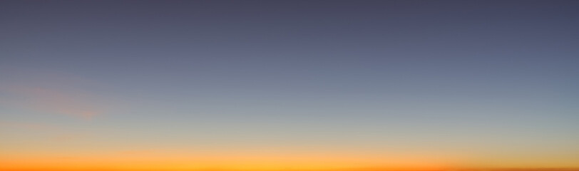 Heaven at early morning with copy space. Sunset, sunrise backdrop.Predawn clear sky with orange horizon and blue atmosphere. Smooth orange blue gradient of dawn sky.