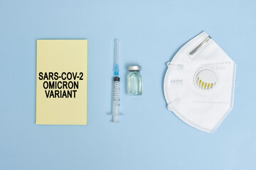 Omicron variant text on piece of paper. New covid variant from South Africa. Vaccine vial, syringe...