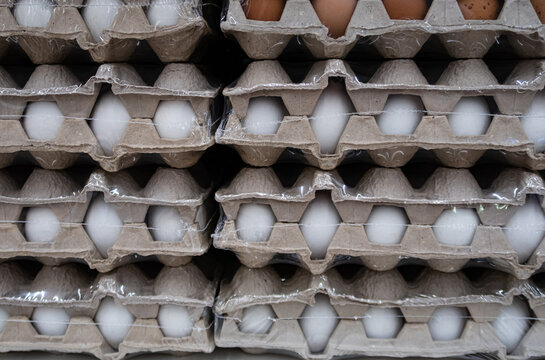 fresh eggs lying in cardboard boxes on a rack