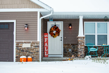 Residential house decorated for autumn with snow on the ground