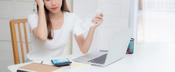 Young asian woman calculating expenses household about finance and frustrated on desk at home, girl...