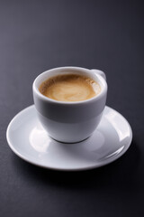 Cup of coffee on dark paper background. Close up.