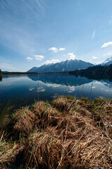 Vorfrühlingsstimmung am Barmsee in den bayerischen Alpen mit Blick vom Seeufer und Bergpanorama Landschaft im Hintergrund in der Morgensonne 