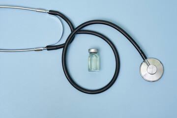 A vial with medical drug, face mask and stethoscope. Coronavirus COVID-19 vaccine vials, syringe...