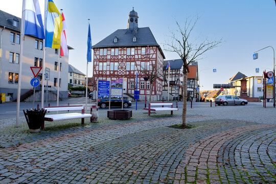 Usingen, Germany, November 2021: European medieval architecture of modern city in half-timbered style, cars driving on road in city center, concept of cultural tourism, travel, excursions in old town