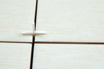 Obraz premium one white cross in the joints of tile tiles, the concept of tile laying repair