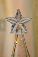 Etoile de verre au sommet d'une bouteille contenant une guirlande éclairée