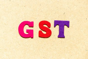 Color cloth alphabet letter in word GST (Abbreviation of Goods and Service Tax) on wood background