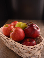 Apples and pear close-up on wooden table.