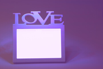 White frame with the inscription love on a purple-pink background