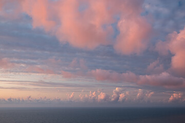 Pink clouds against the blue sky. The sky at sunset over the sea. Day. Georgia. Sunny