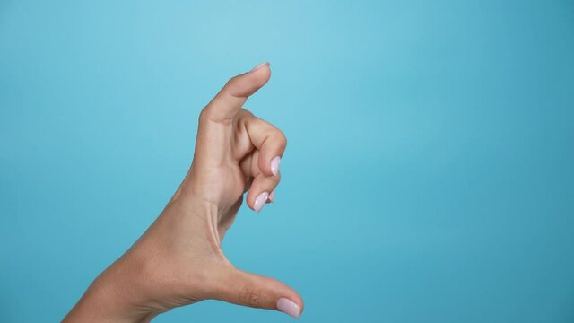 Close-up view stock video footage of single female hand showing different sizes of virtual object from small size to big one and backward