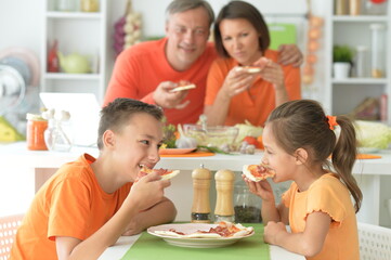 Happy family eating pizza together