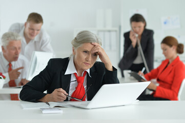 Fototapeta premium Portrait of a senior woman with a laptop in office