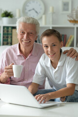 Boy and grandfather with a laptop at home