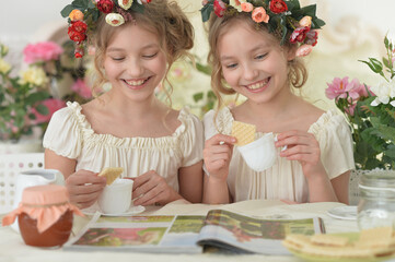 Obraz na płótnie Canvas girls reading magazine, and drinking tea