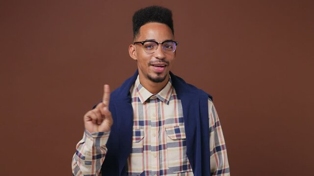 Proactive young african american man 20s wears striped shirt glasses look camera point fingers himself ask say who me no thanks i do not need it isolated on plain dark brown background studio portrait