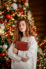 A beautiful girl portrait in a Christmas interior. Christmas tree, decorated fireplace, lots of gifts, Christmas theme. Cozy atmosphere.