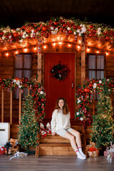 A beautiful girl portrait in a Christmas interior. Christmas tree, decorated fireplace, lots of gifts, Christmas theme. Cozy atmosphere.