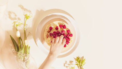 Homemade almond cake with raspberries and white flowers
