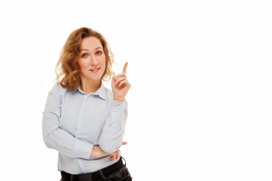 Young happy businesswoman with curly hair standing over white background smiling with happy face looking and pointing to the side with thumb up. Copy Place for your text