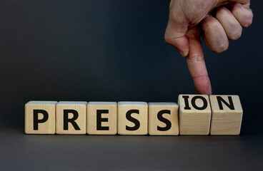 Pression to free press symbol. Businessman turns wooden cubes and changes the word pression to press. Beautiful grey table, grey background. Business and pression to free press concept. Copy space.