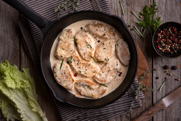 Cooked chicken breast with creamy sauce in frying pan