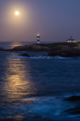 Fototapeta na wymiar November Full Moon over the Illa Pancha lighthouse and hotel, in Ribadeo, Galicia, Spain!