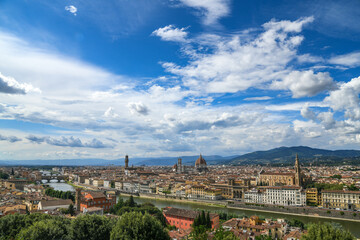 Fototapeta na wymiar Beautiful panoramic view of Florence in a sunny day with blue sky and clouds. Italian panorama of a city in Tuscany. Top aerial landscape view of an ancient historical tourist destination in Europe.