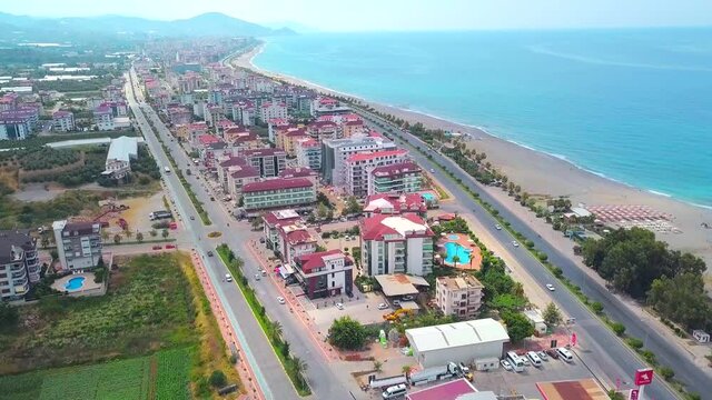Beautiful view from the drone. You can see a beautiful ocean and large houses with a road, you can see beautiful green mountains from behind.