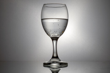 Cola de cristal con licor transparente, fondo gris