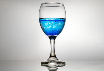Cola de cristal con licor azul, fondo gris