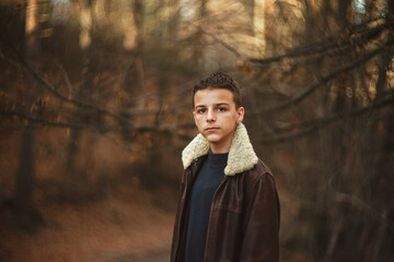 young teenager stands in the woods in late November