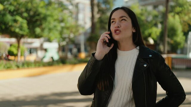 Young hispanic woman smiling confident talking on the smartphone at park
