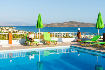 woman near swimming pool with laptop on crete