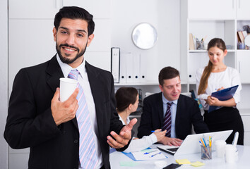 Smiling businessman with professional business team behind during joint work