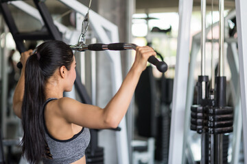 Asian woman pumping back muscles in fitness