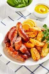 fried sausages on a plate with potatoes